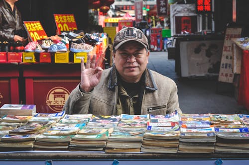 Free Man in Brown Coat in Front of Books Stock Photo