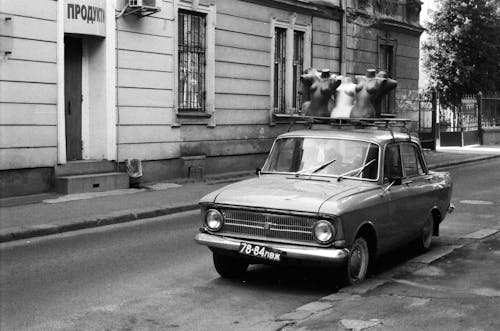 마네킹을 운반하는 자동차의 흑백 사진