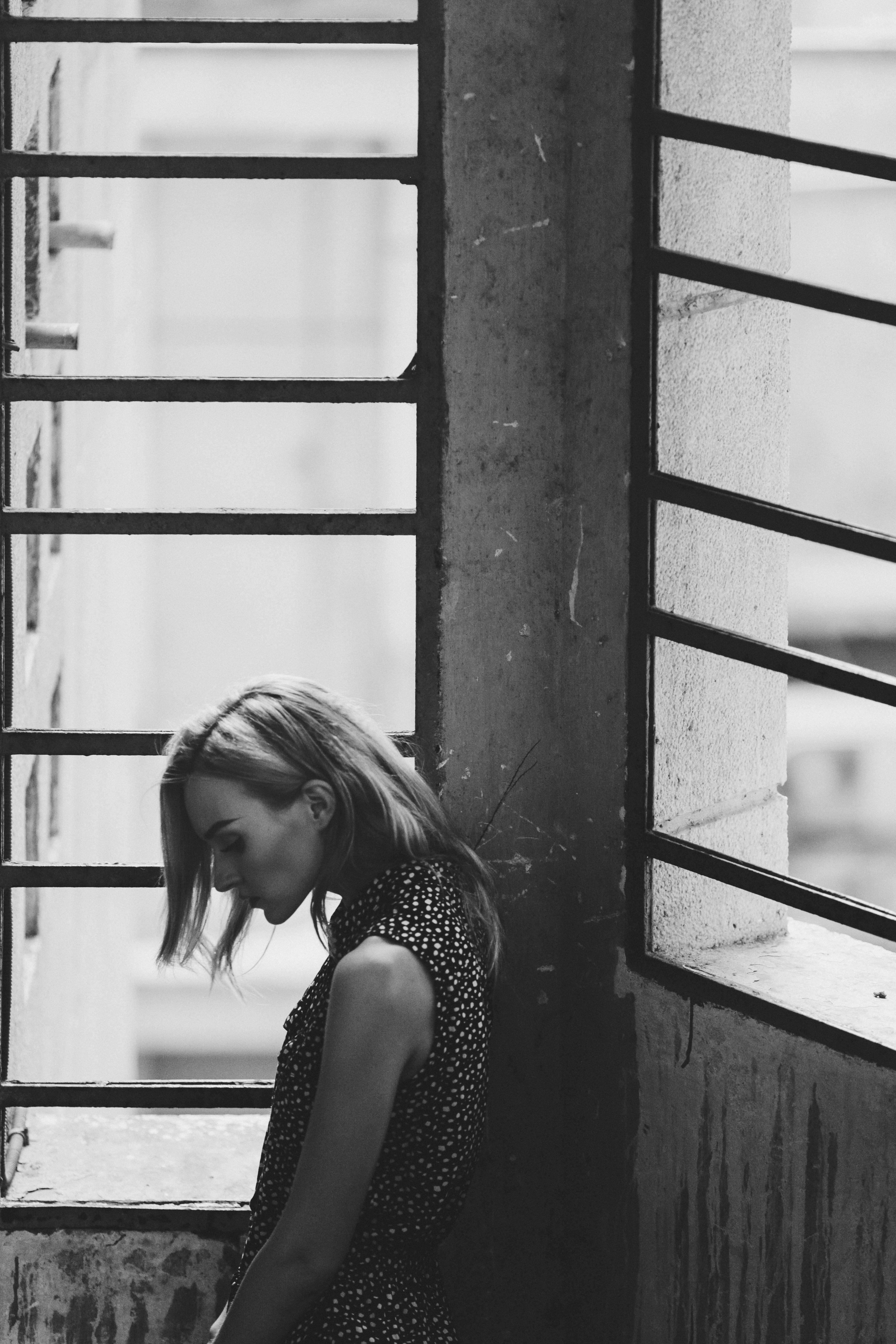 a woman sitting in a window looking out