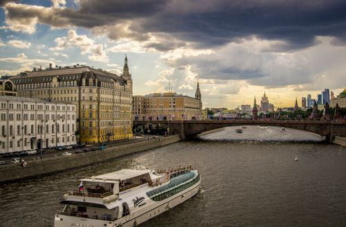 Free A captivating view of a boat on the Moscow River with historic buildings and skyline. Stock Photo