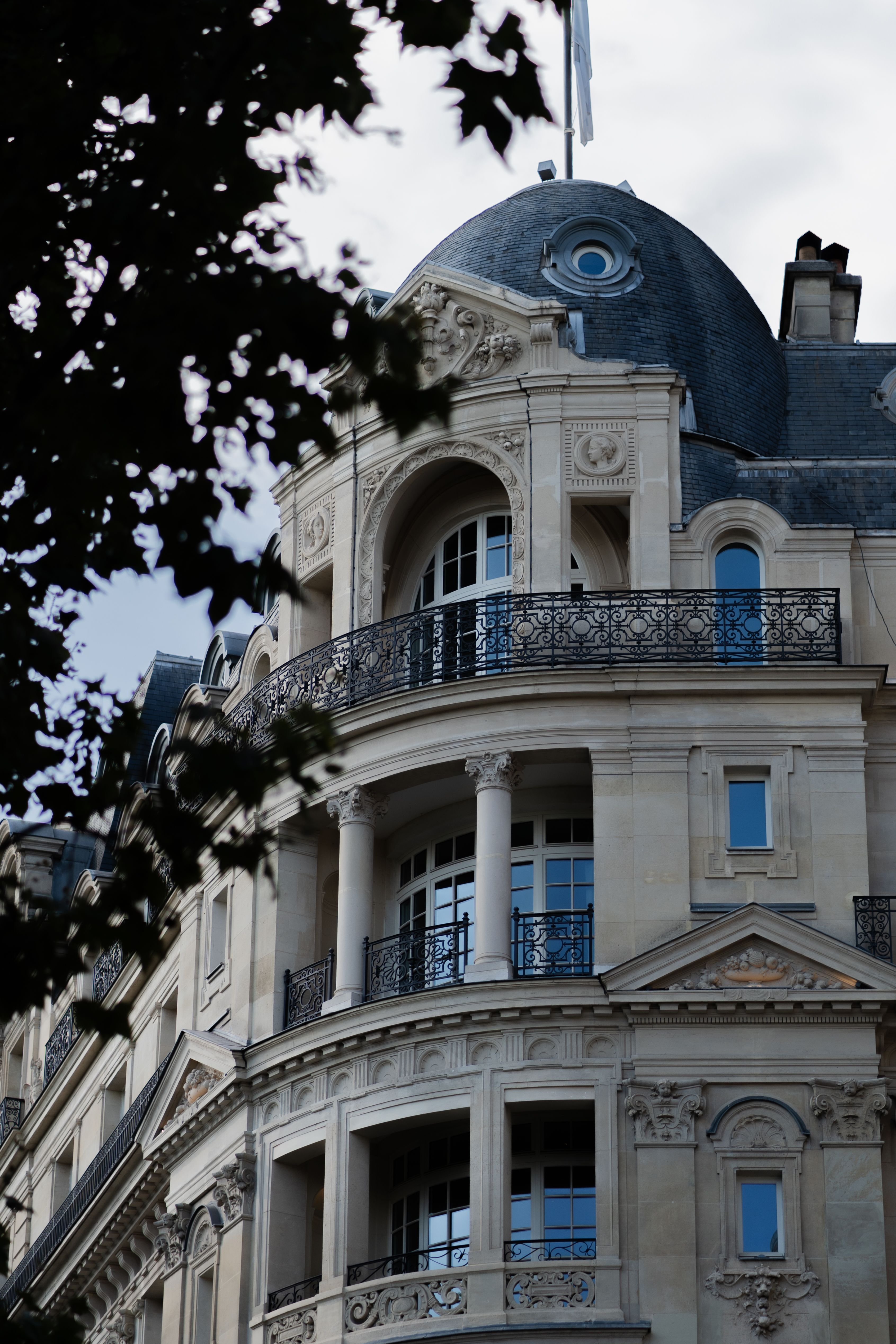 Immeuble parisien orné surmonté d’une horloge, à l’angle d’un boulevard.