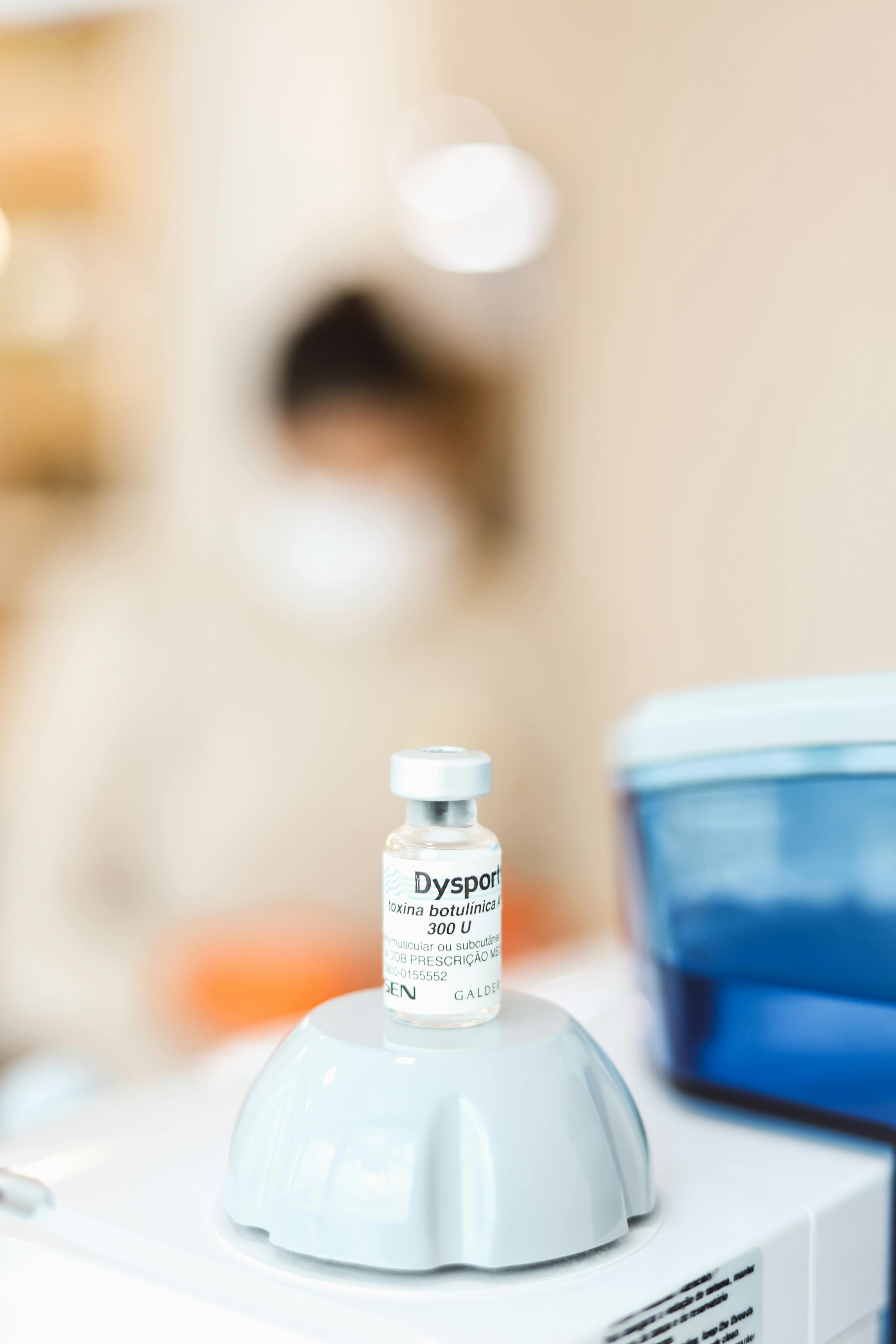 Close-up of a vial labeled Dysport in a clinical environment, emphasizing healthcare and medical treatment.