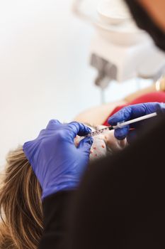 A medical professional performs a facial injection on a patient in a clinic setting.
