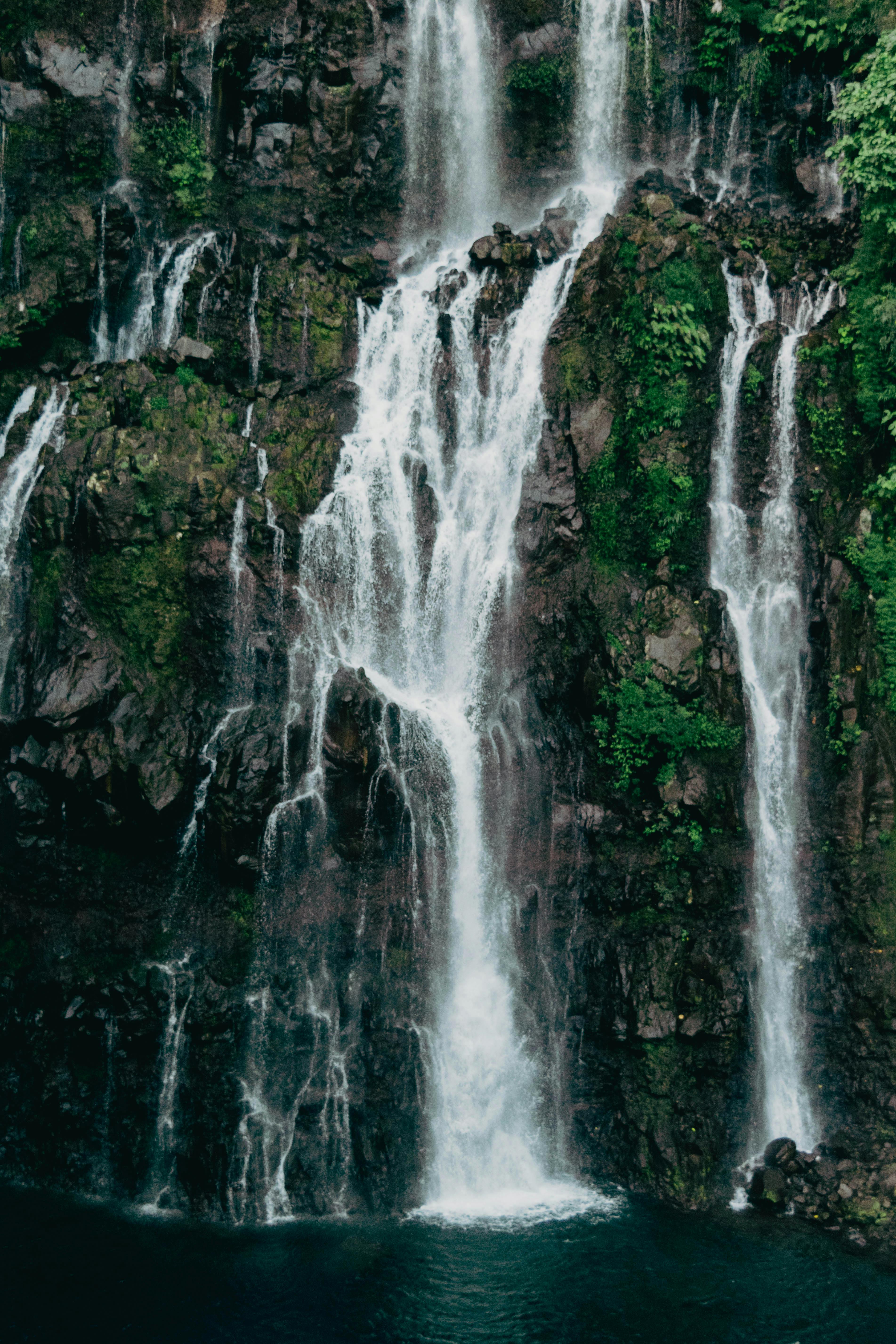 Breathtaking waterfall cascading amidst lush greenery at La Réunion, France.