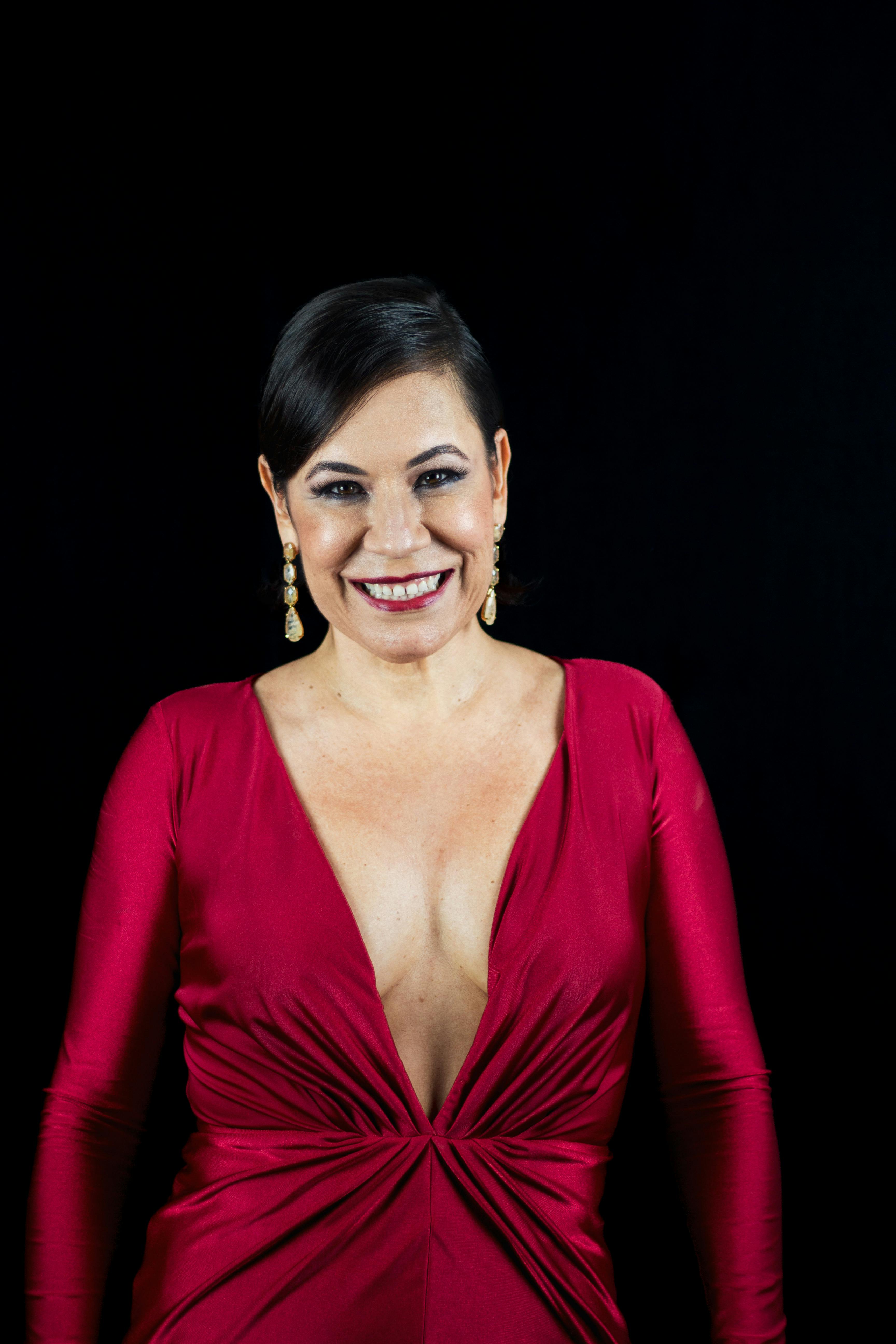 a woman in a red dress smiling for the camera