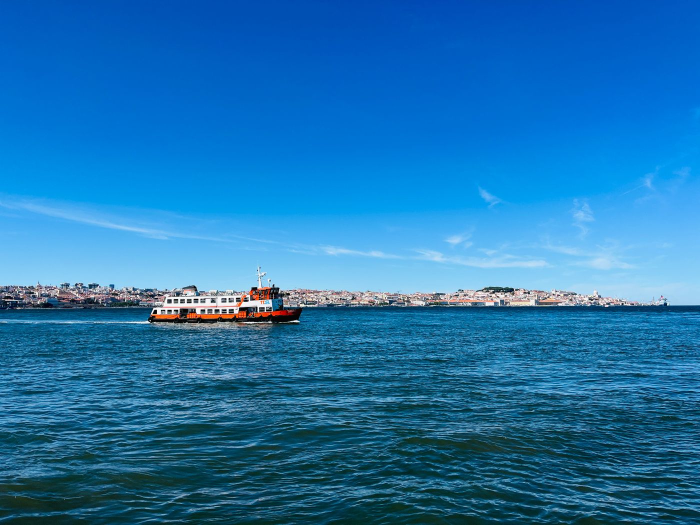A ferry crossing the Tagus River with Lisbon's skyline behind — photo by Henrique Baldy on Pexels