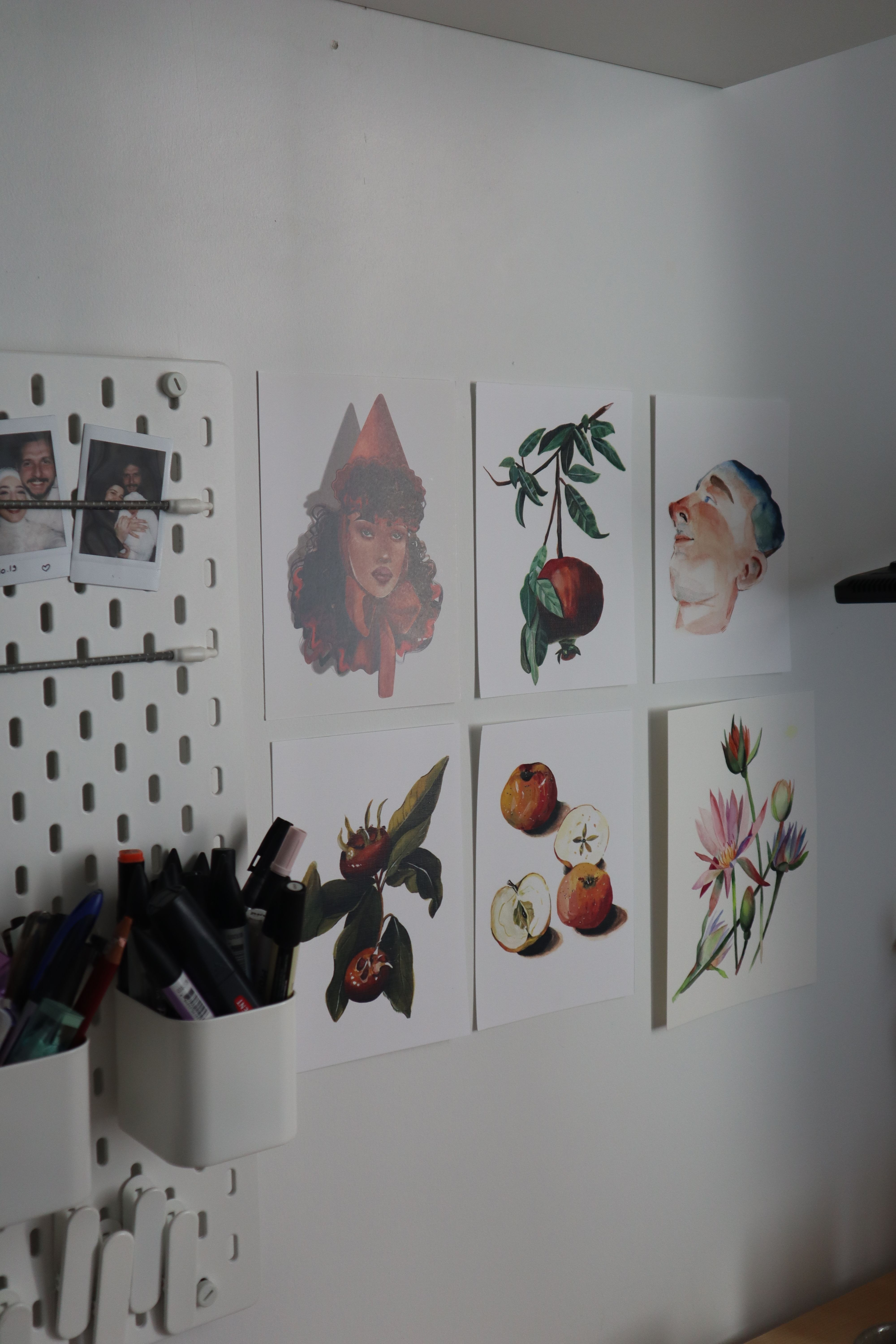 A studio wall displaying artistic prints and organized sketch supplies for creative inspiration.