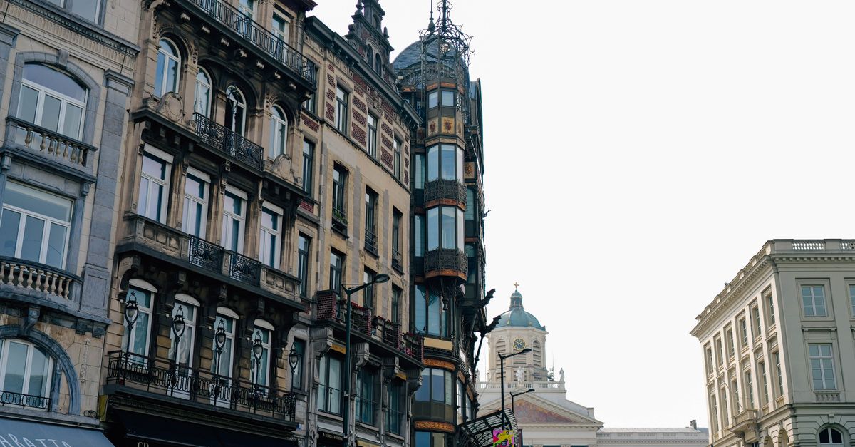 Charming view of a European street with historic buildings and a person crossing the road.