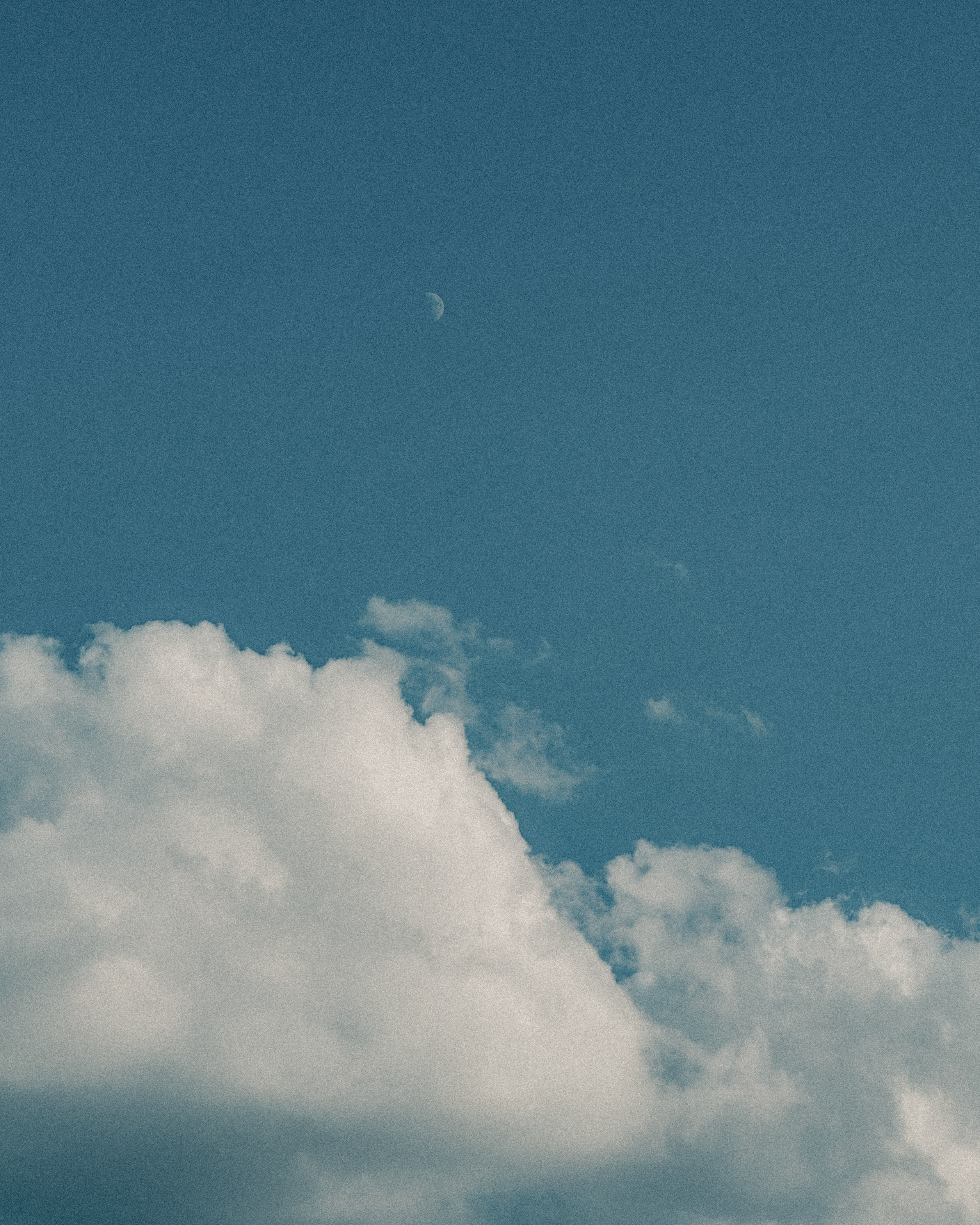 A blue sky with clouds and a moon in the distance · Free Stock Photo