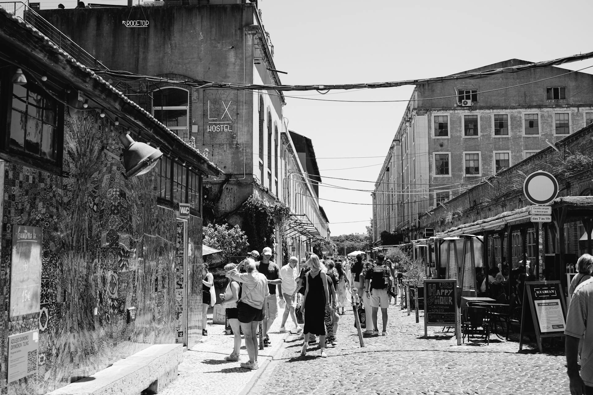 Black and white photo of people exploring the vibrant streets of LX Factory, Lisbon.