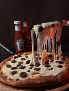 Sizzling pepperoni pizza with melted cheese pulled up, perfect for parties or dinners.
