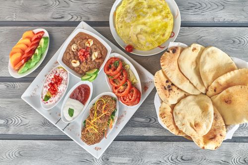 Free A vibrant spread of Middle Eastern dishes featuring hummus, falafel, and fresh vegetables. Stock Photo
