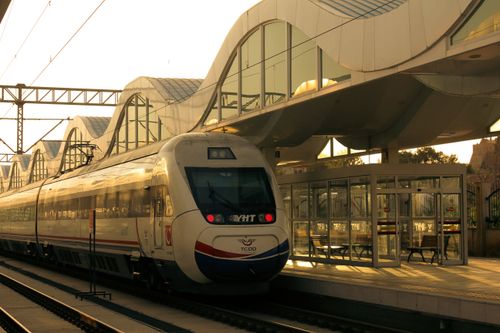 Free A sleek train arrives at a contemporary urban railway station under evening light. Stock Photo