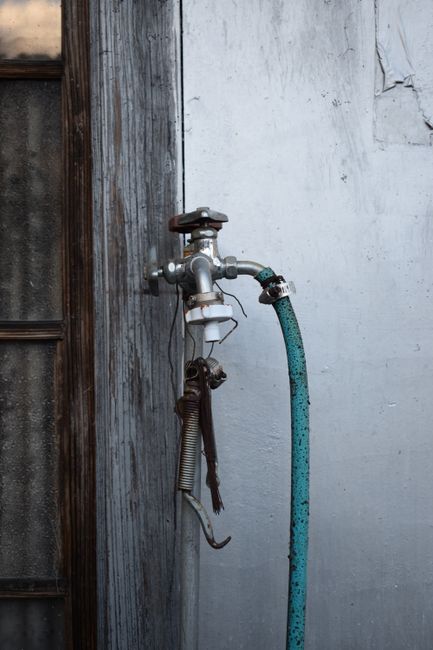 RV water hose connected to a campground spigot with an inline water filter and pressure regulator