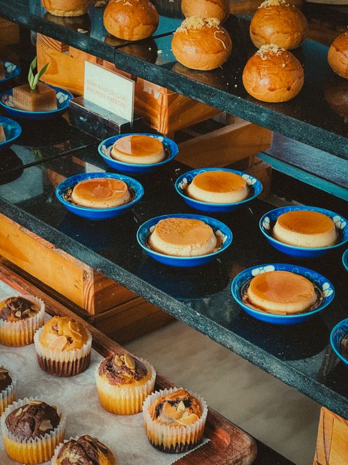 Free A delicious assortment of pastries, flans, and muffins displayed on trays indoors. Stock Photo