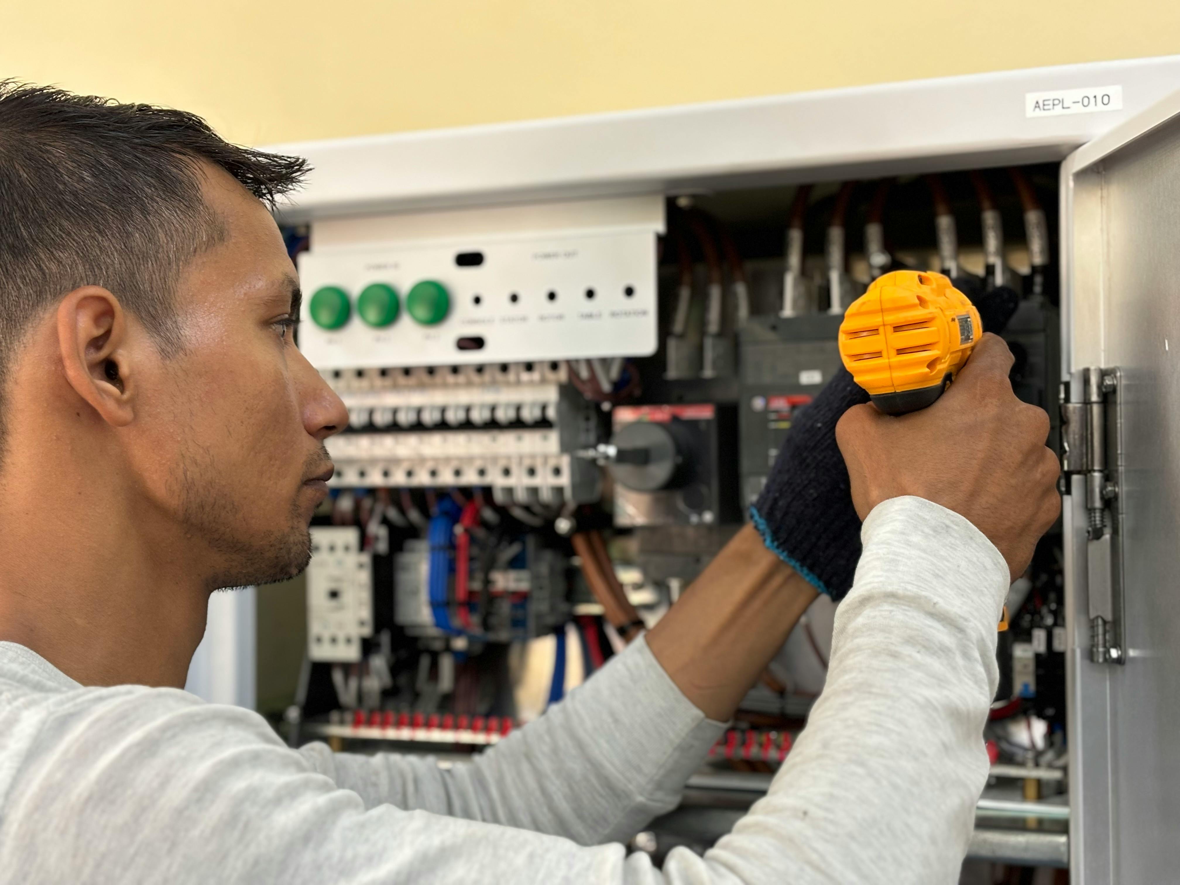 A man is working on an electrical panel