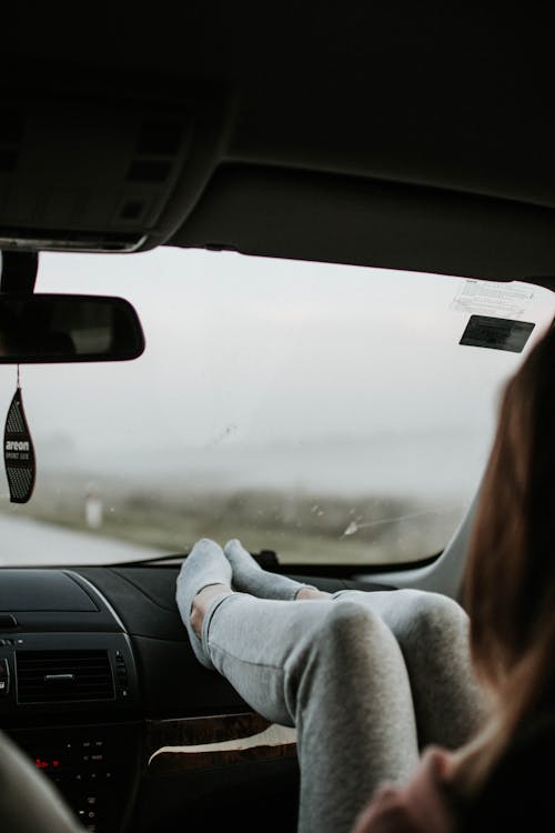 Woman Resting Both Feet on Dashboard