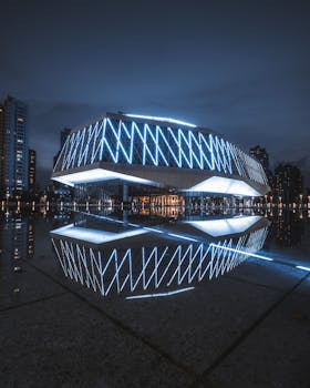夜晚，一座未来派建筑的明亮灯光倒映在城市景观的水面上