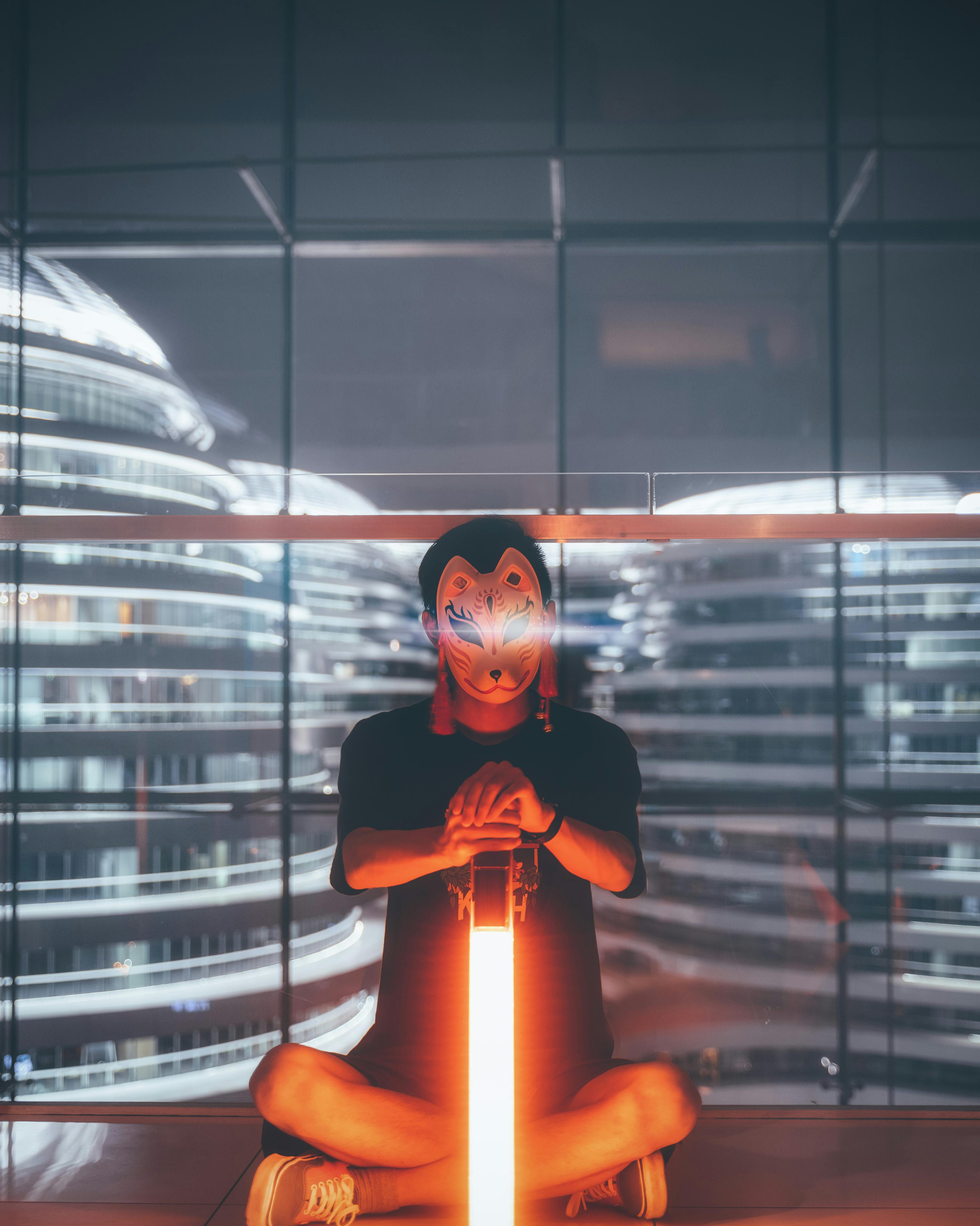 室内，一个神秘的蒙面人坐在霓虹灯光下，背景充满未来感