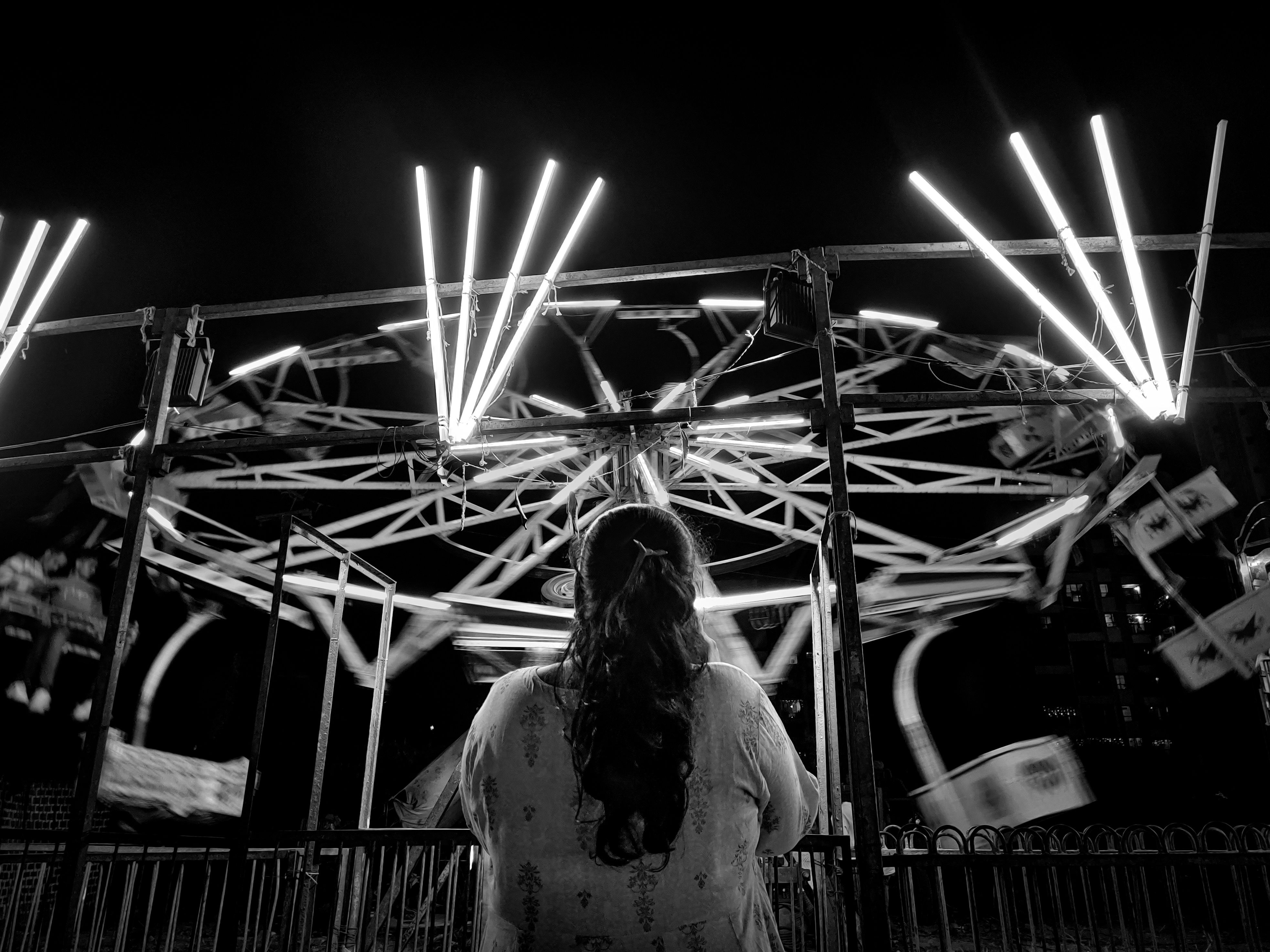 A woman watching amusement ride in the night · Free Stock Photo