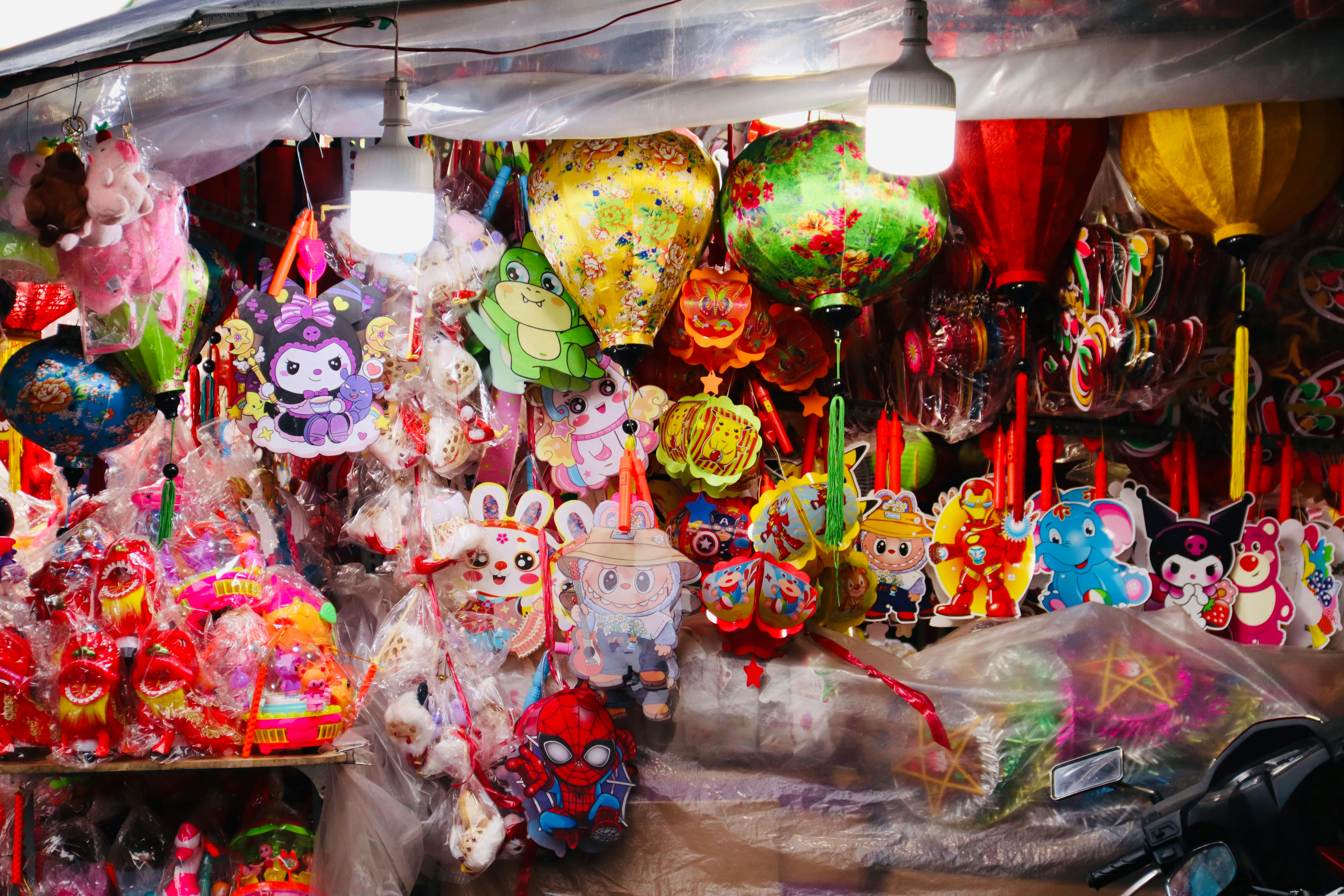 a bunch of different colored balloons hanging from a ceiling