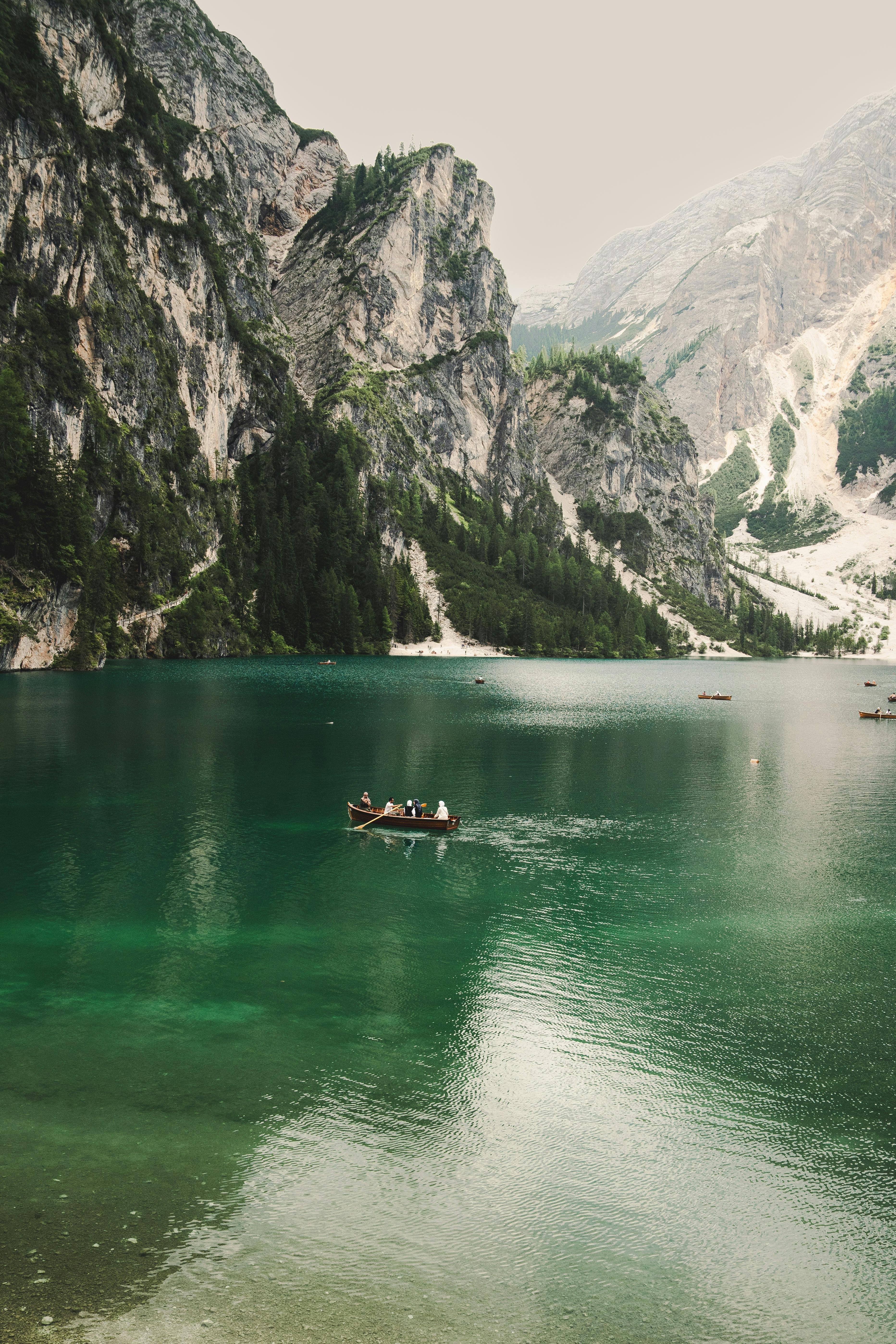 Peaceful view of a rowboat on emerald waters surrounded by the Dolomite mountains in Italy.