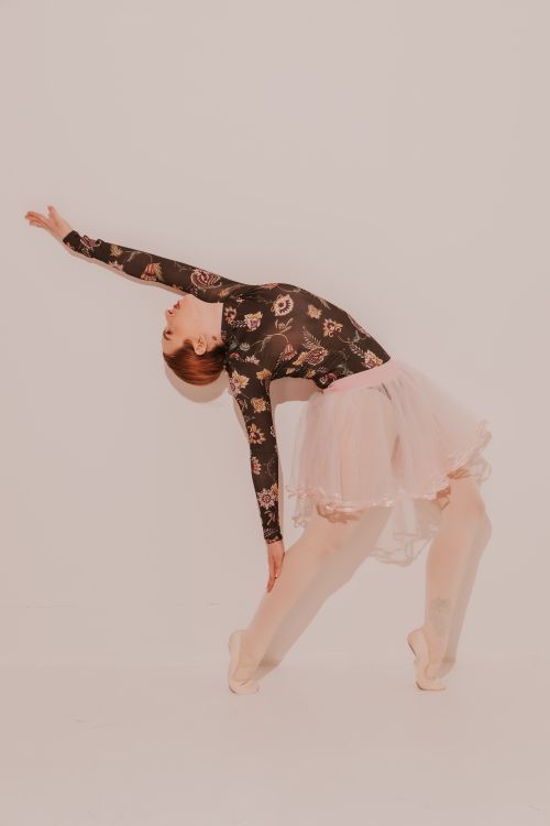 Free A ballerina gracefully poses in a pink tutu and floral bodysuit, showcasing elegance and poise. Stock Photo