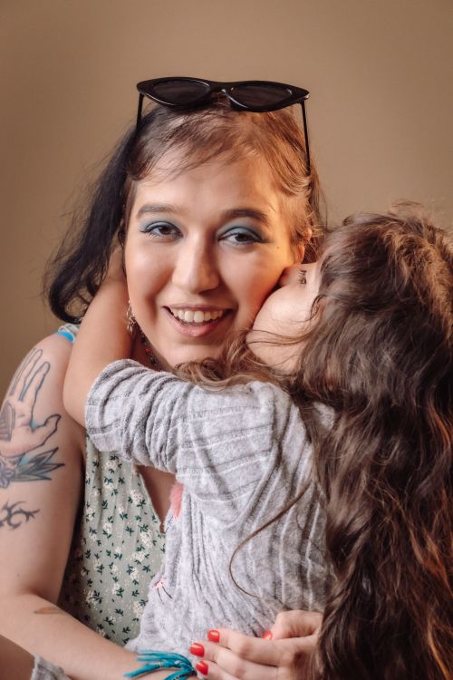 Free A young mother and her daughter embracing, showcasing love and connection indoors. Stock Photo