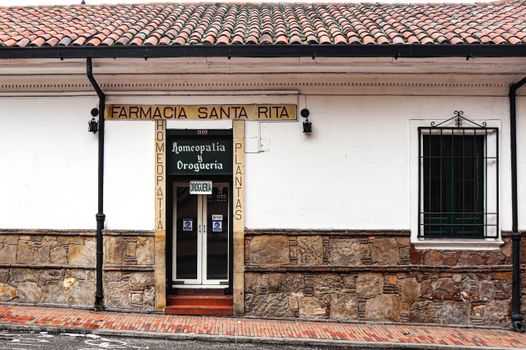Exterior view of a vintage pharmacy with a classic stone wall facade and tiled roof.