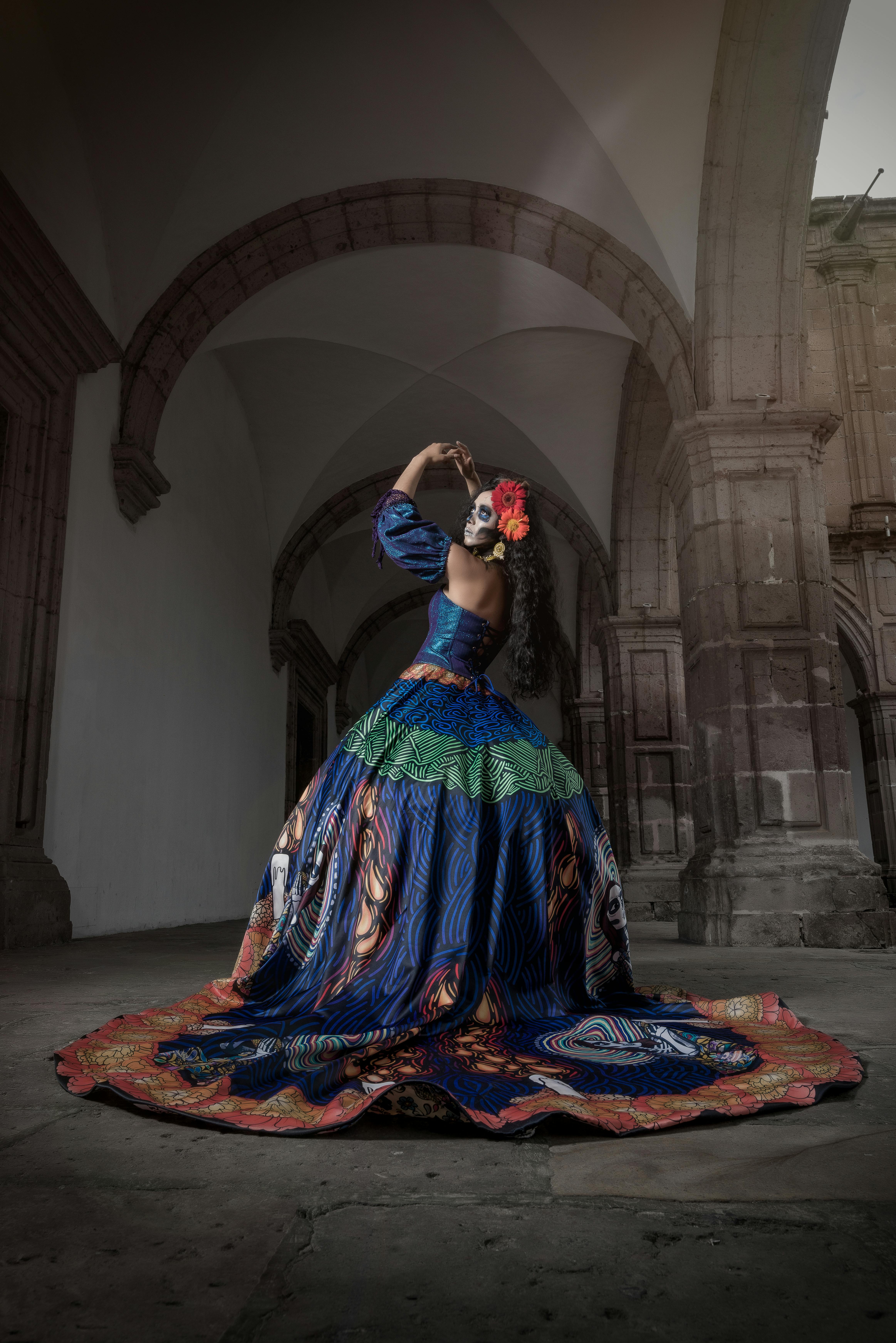 calavera catrina in a ball gown standing in an arcade