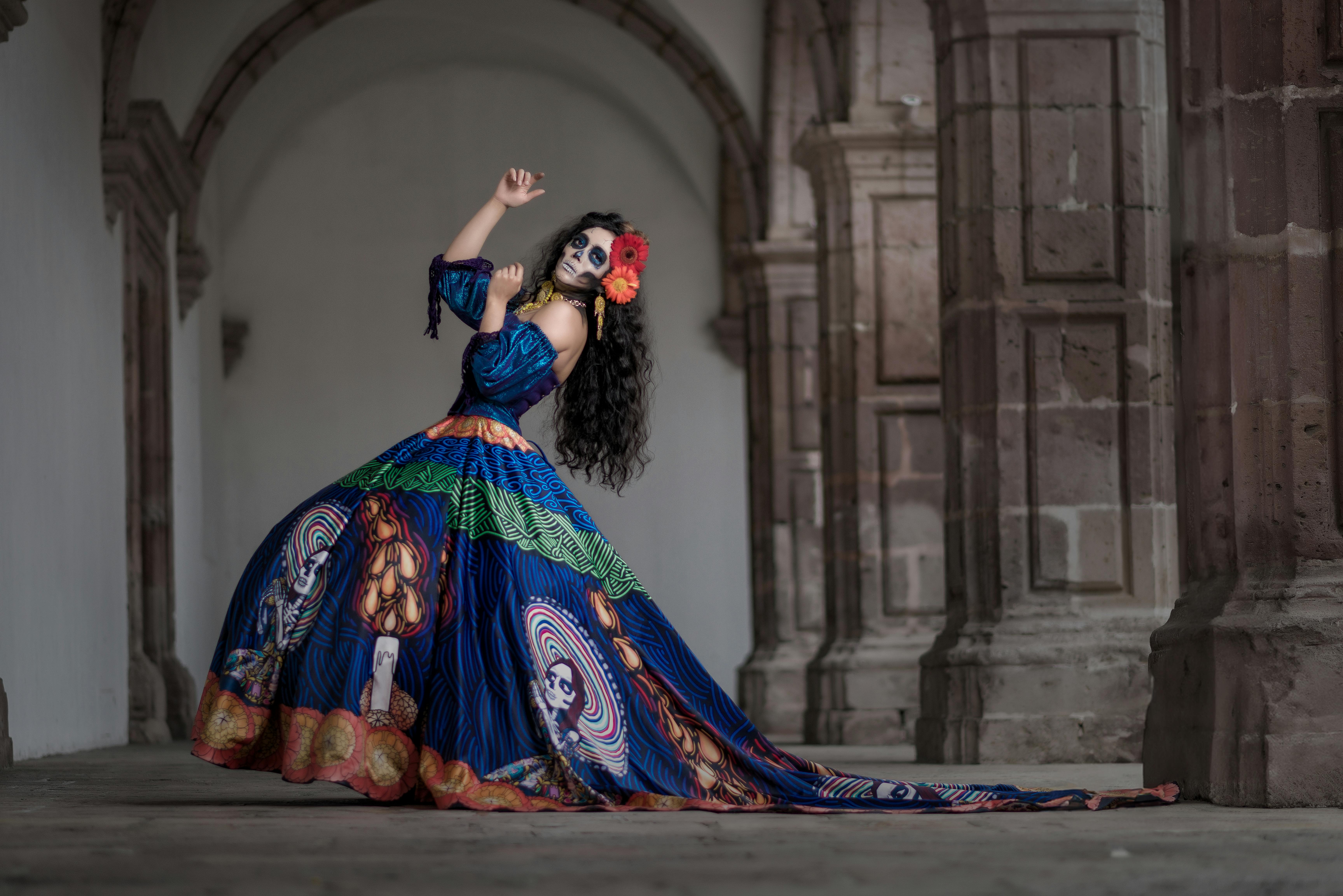 la calavera catrina in a ball gown dancing under the arcade