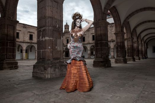 Model wearing artistic fashion poses in an archway of historic architecture.