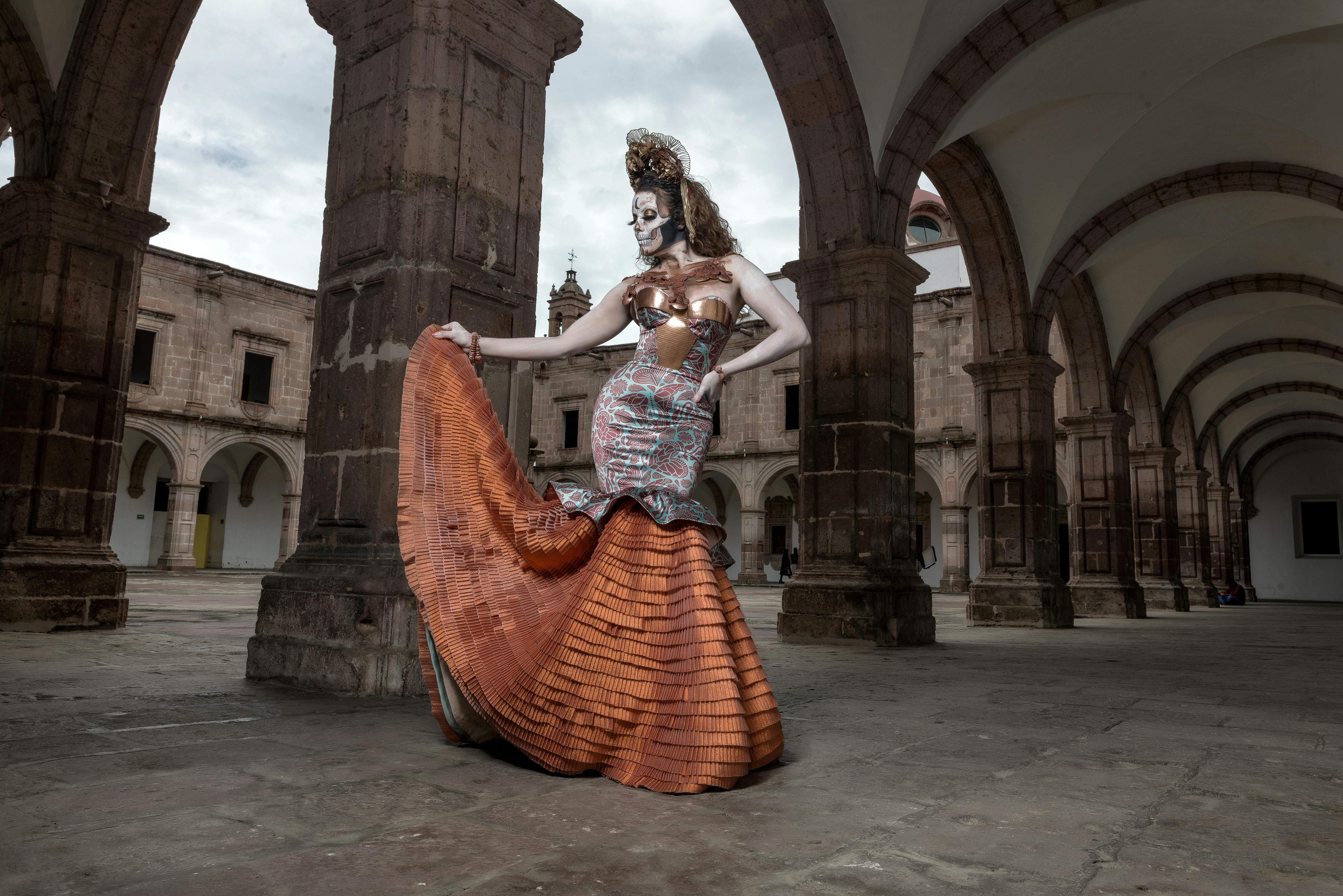 calavera catrina in mermaid silhouette dress posing under the arcade