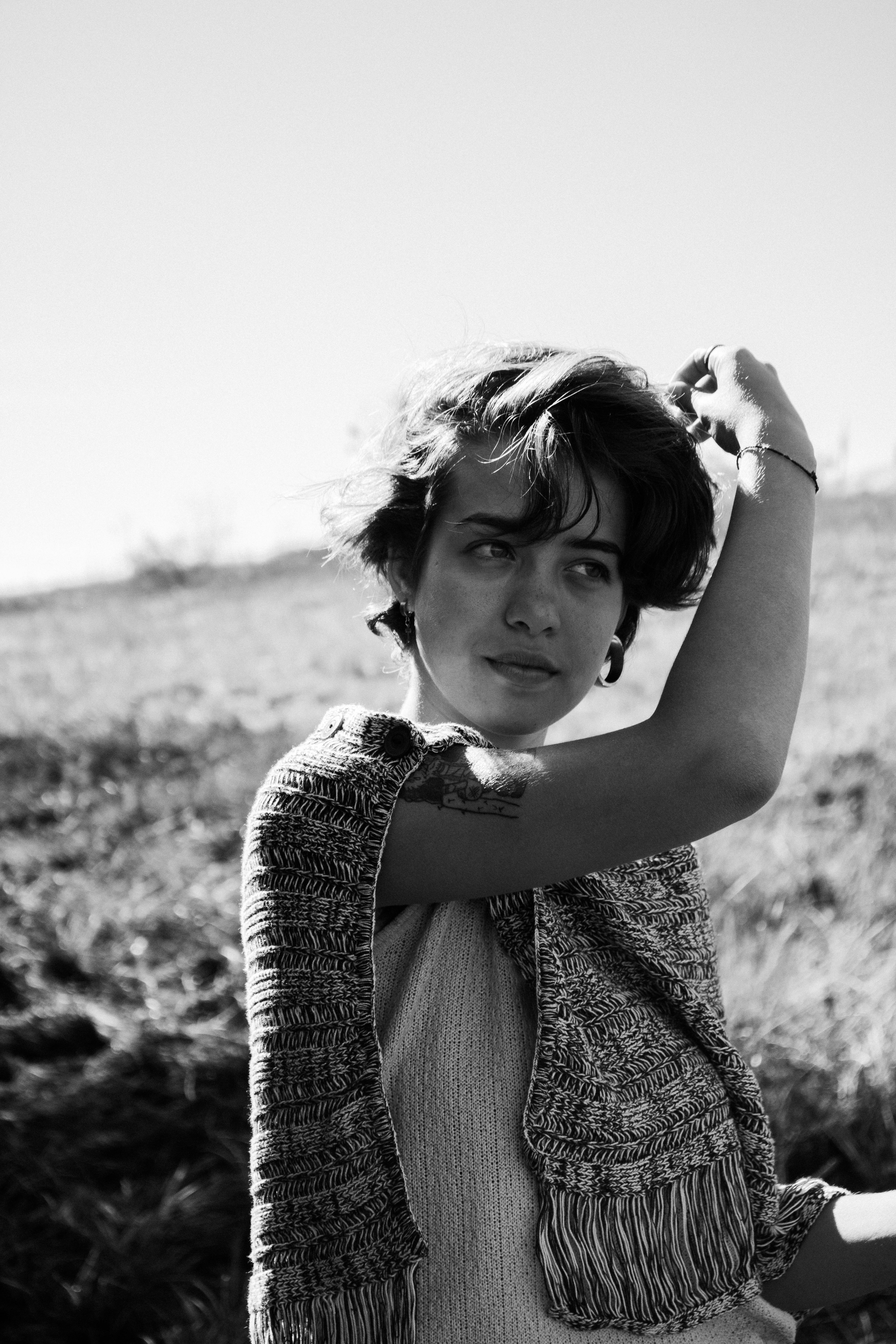 Monochrome portrait of a woman posing outdoors with a casual scarf.
