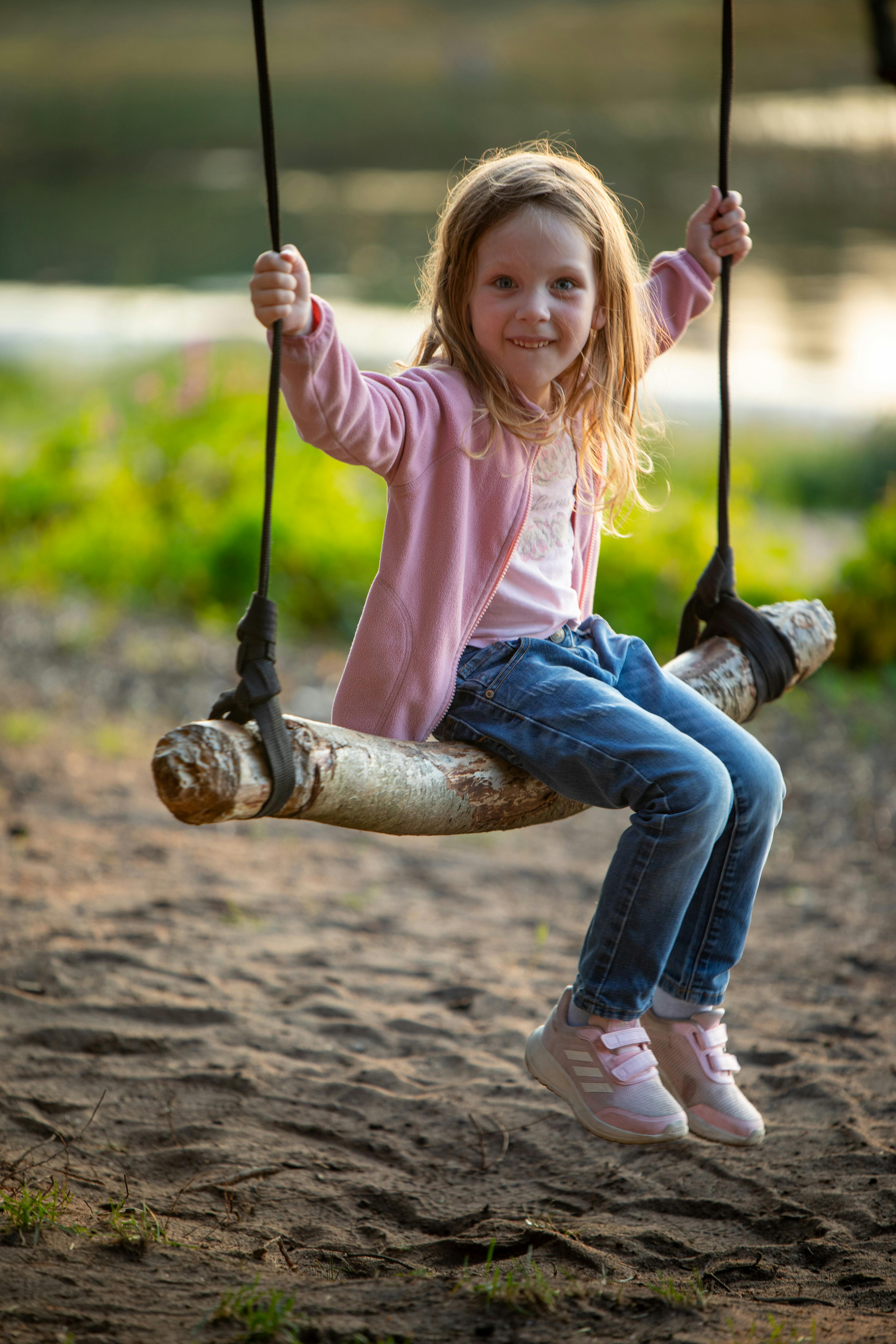 a little girl on a swing at the park