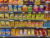 Colorful snack packages neatly displayed in a supermarket aisle showcasing Asian food variety.