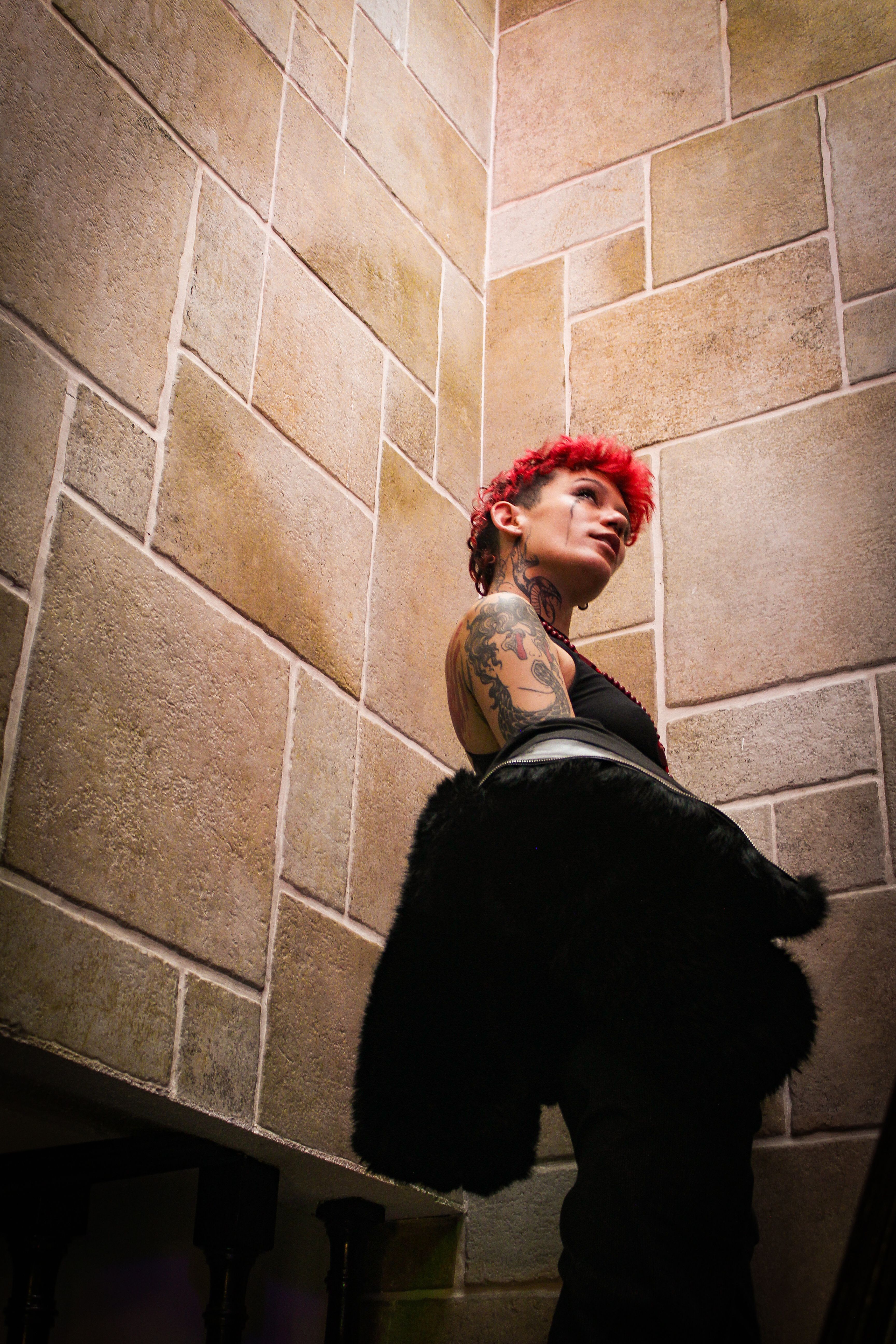 A woman with red hair standing in front of a wall · Free Stock Photo