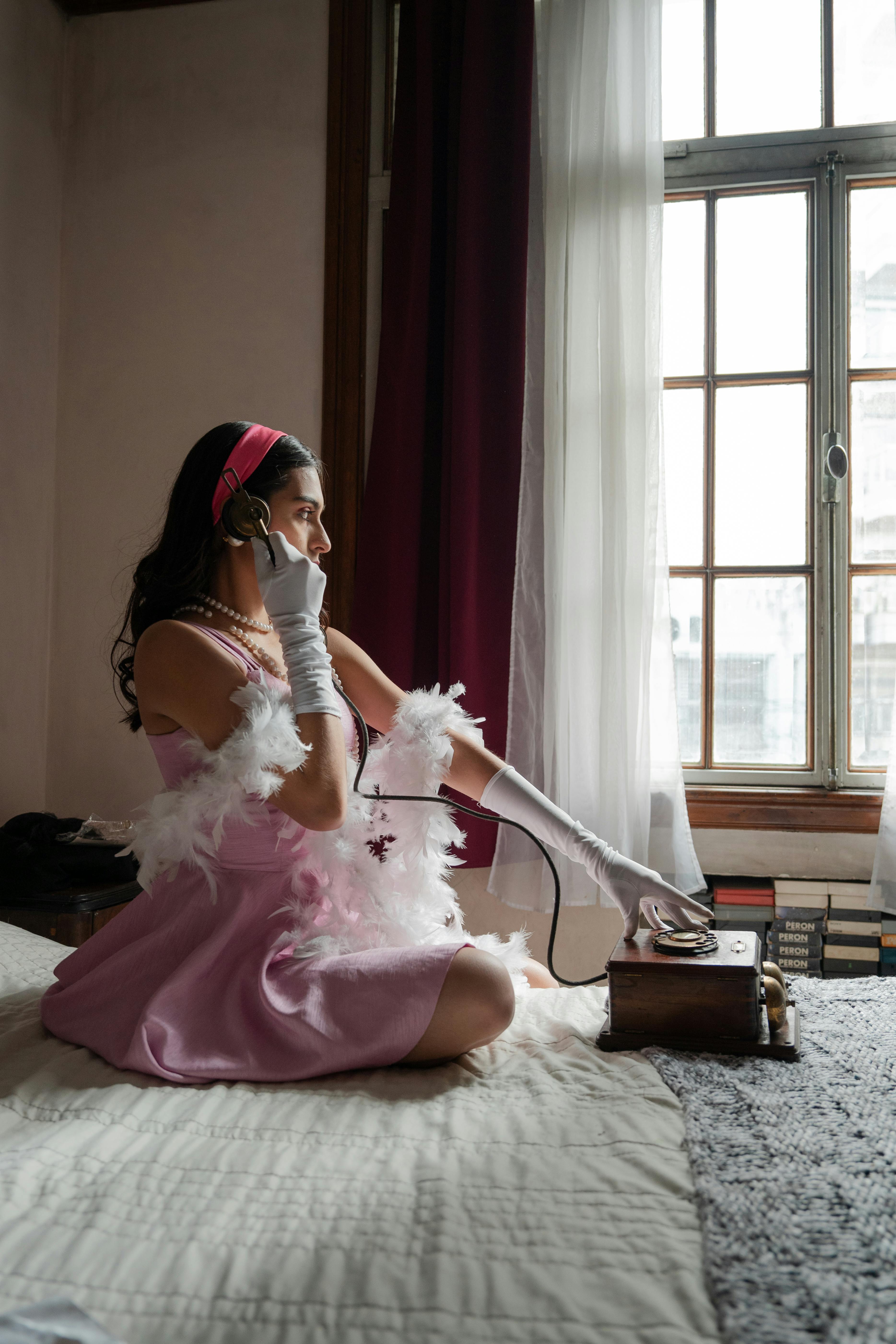 model in pink dress posing with vintage telephone