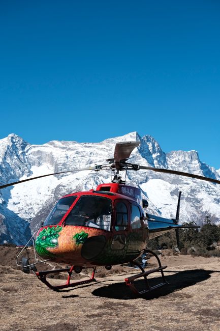 Helicopter on the ground with snow-covered Himalayan mountains in the background