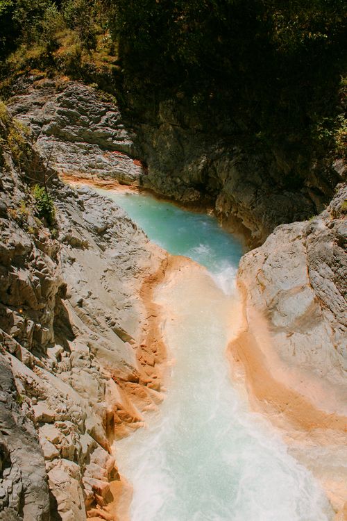 Free Stunning aerial view of a waterfall cascading through a rocky canyon surrounded by nature. Stock Photo