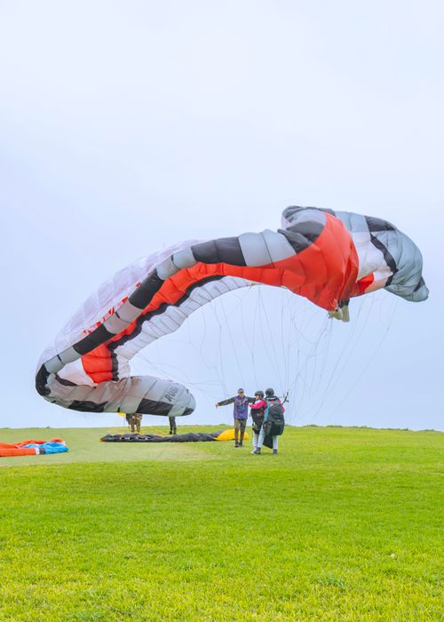 Free Paragliders getting ready for a flight in the vibrant fields of Lima, Peru. Stock Photo