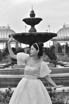 Black and white bridal portrait by a grand fountain, showcasing elegance and style.