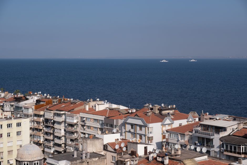 Cityscape of İzmir with modern apartments overlooking the Aegean Sea, showcasing a vibrant coastal lifestyle.