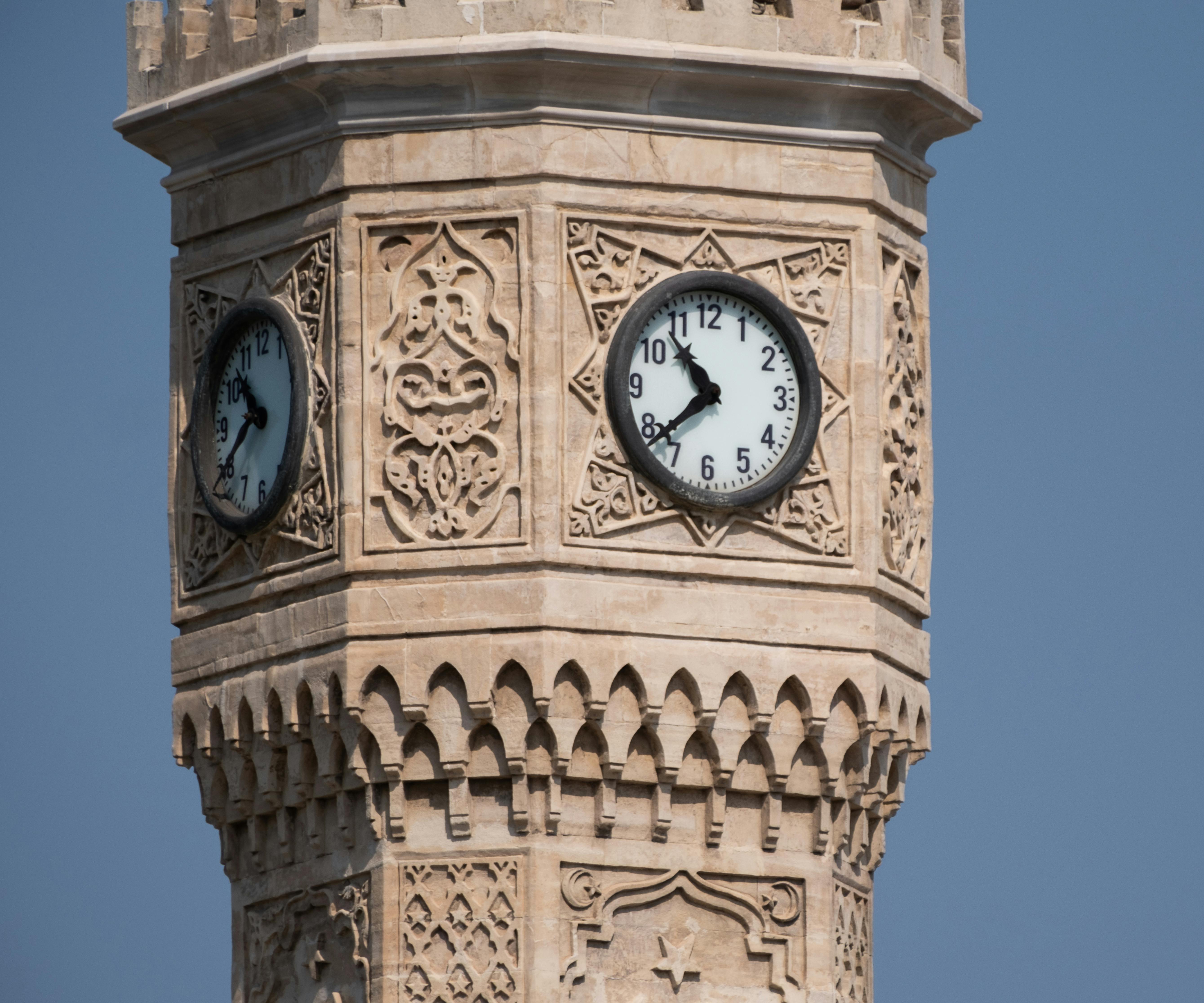 a clock on the top of a tower with a blue sky