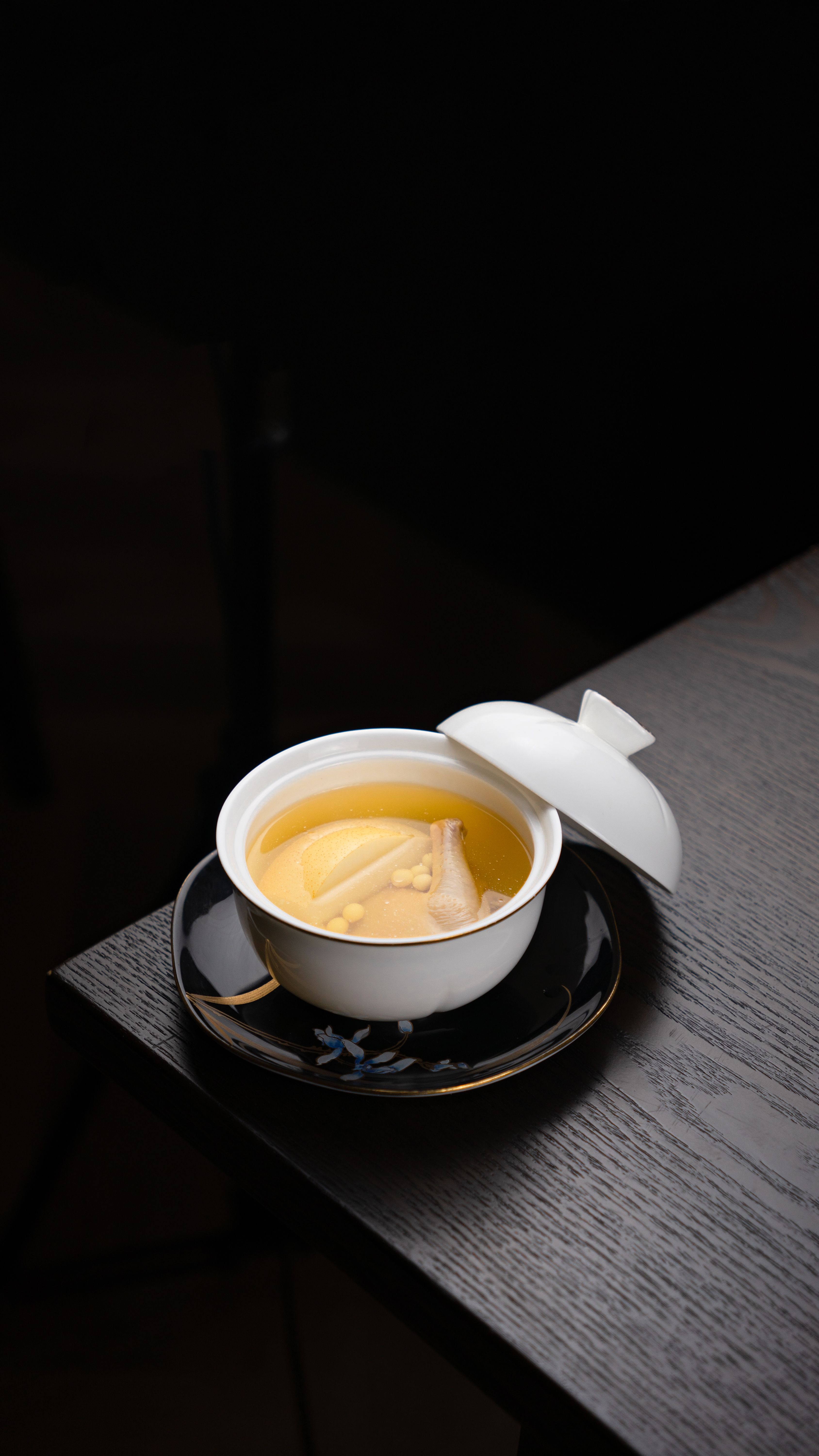 Delicately served Asian soup in a white ceramic dish, perfect for food photography.