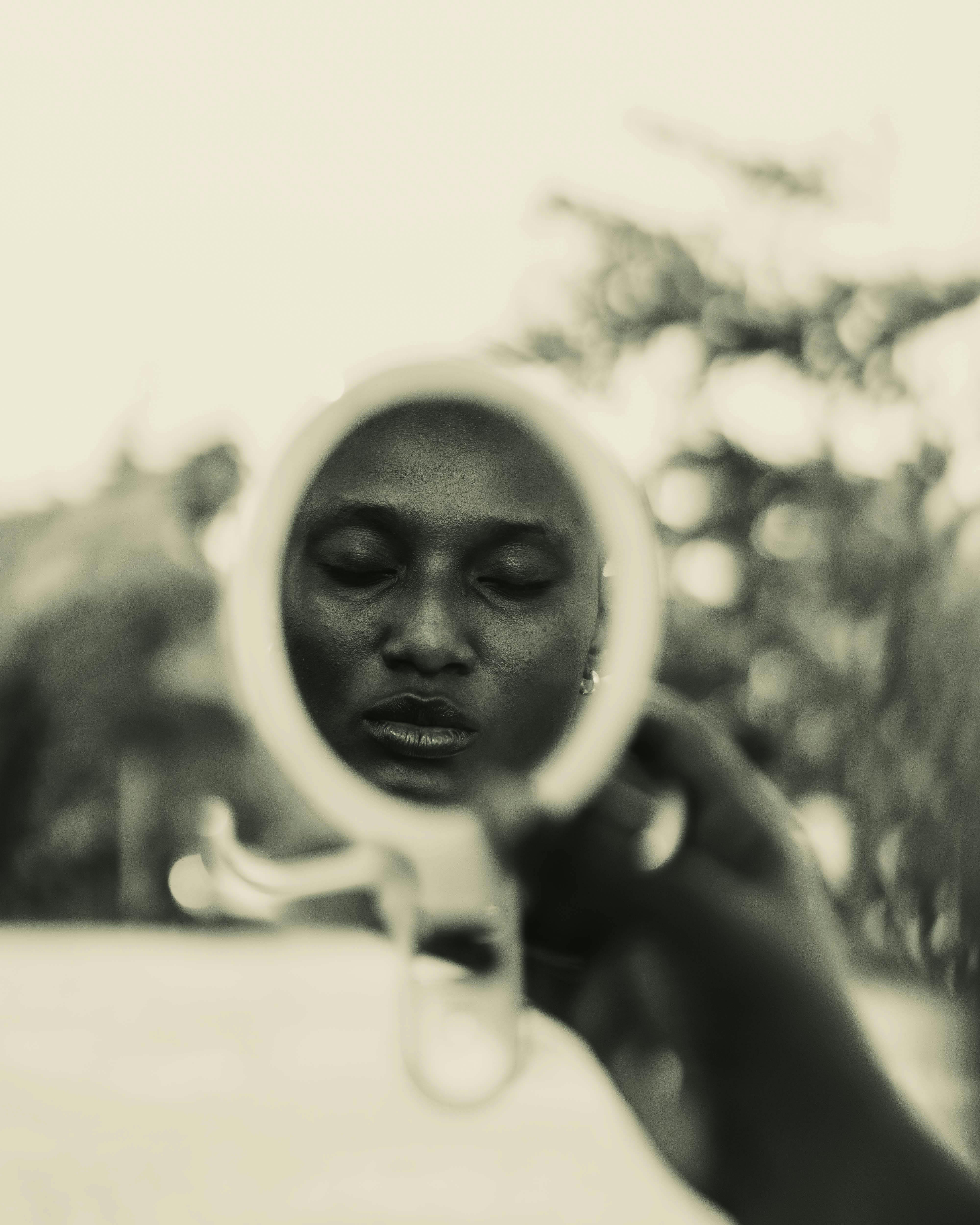 A serene portrait reflected in a handheld mirror, capturing calmness and depth.