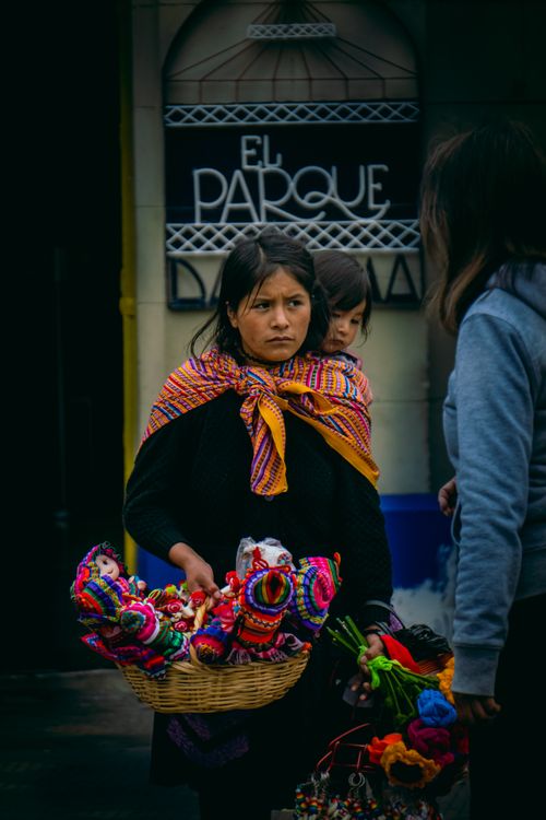 Free Woman selling handmade crafts on a street, vibrant colors and traditional wear. Stock Photo