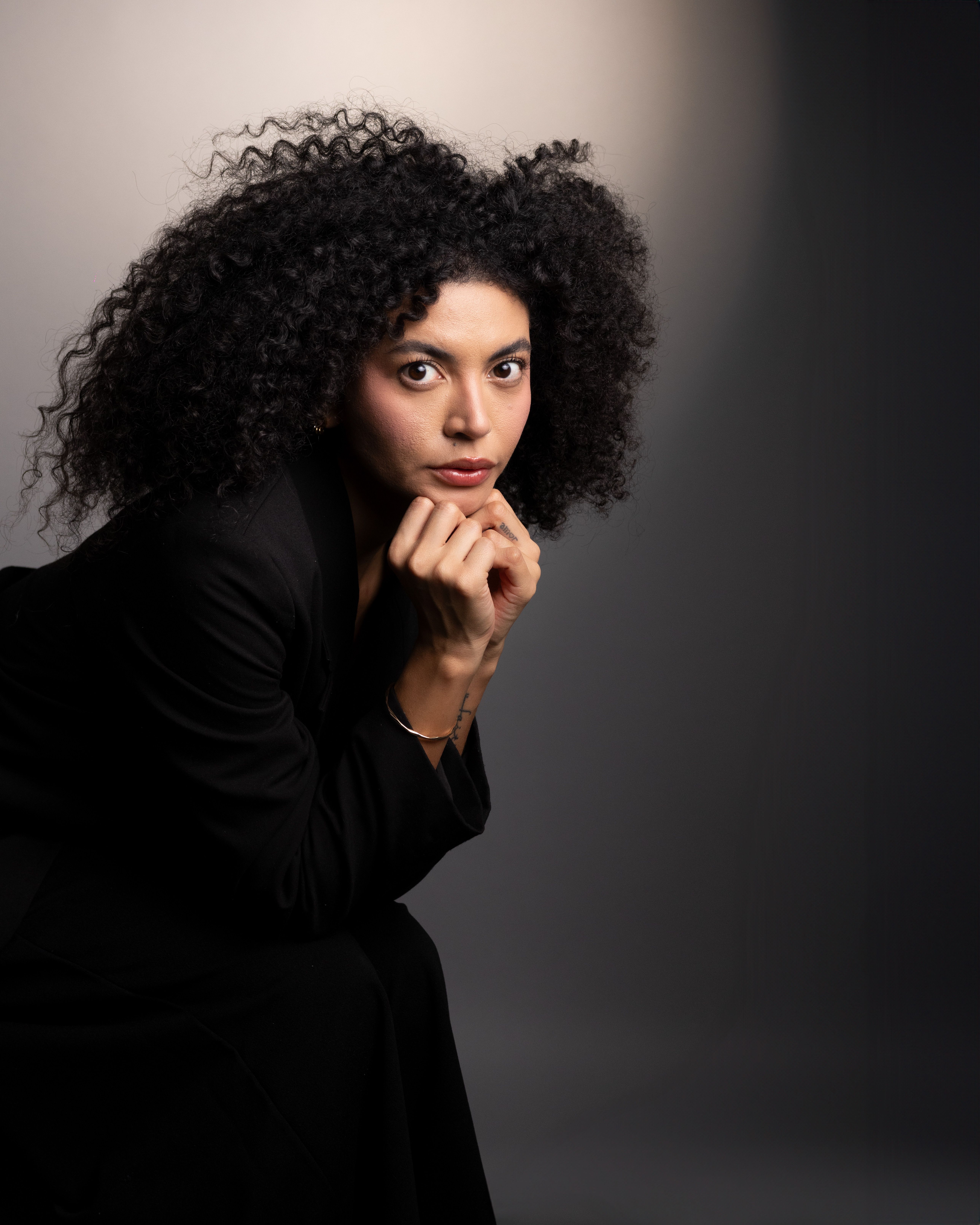 A woman with curly hair posing for a portrait · Free Stock Photo