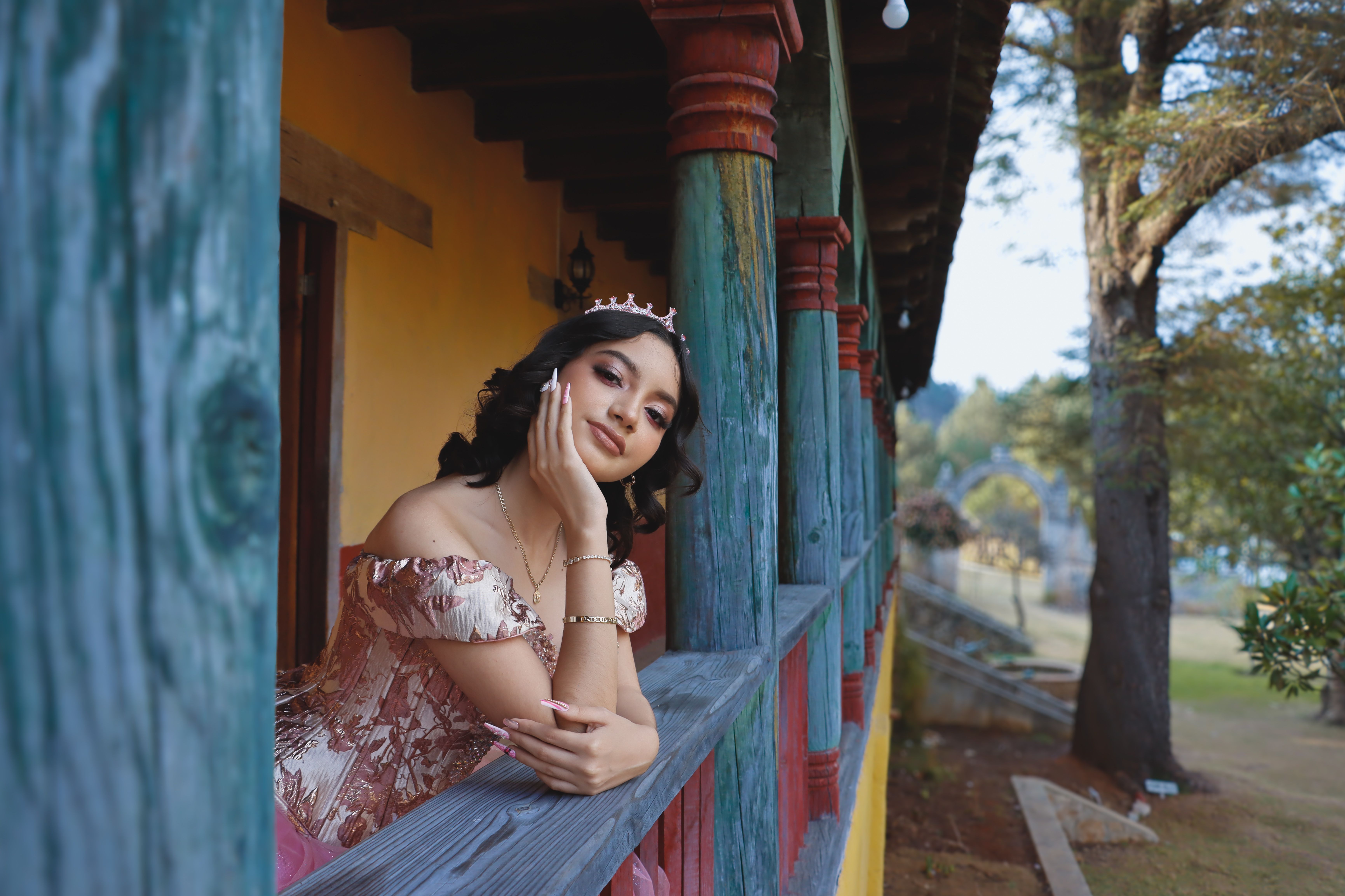 A woman in a pink dress leaning on a railing · Free Stock Photo