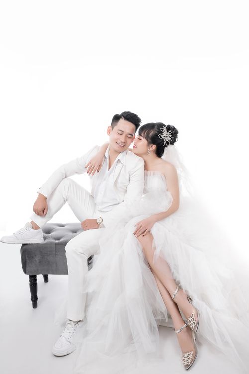 Free Stylish bride and groom in a professional studio setting, embracing love and elegance. Stock Photo